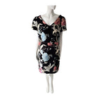 Mannequin wearing a black dress with colorful floral pattern on a white background