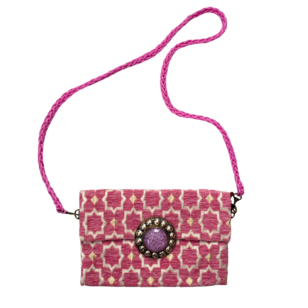 Moroccan-inspired pink patterned shoulder bag with lilac stone embellishment and braided strap. 