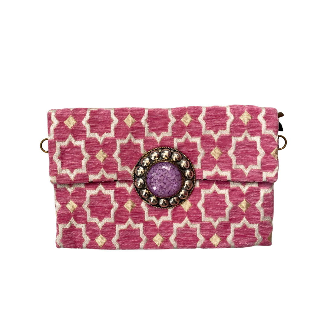 Pink patterned clutch with a decorative button on a white background