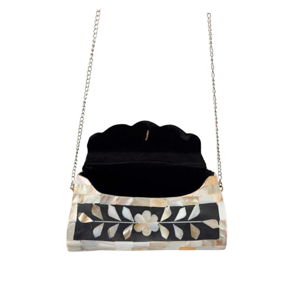Black handbag with floral pattern and chain strap on a white background