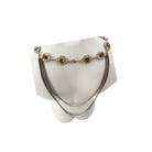 Necklace with floral designs on a white stand against a white background