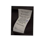 Clothing label with washing instructions on a black fabric background