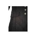 Close-up of a black textured garment with buttons on a white background