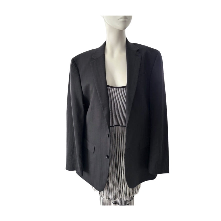 Black blazer over a striped dress on a mannequin against a white background
