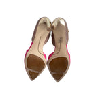 Pair of pink high-heeled shoes with gold soles on a white background