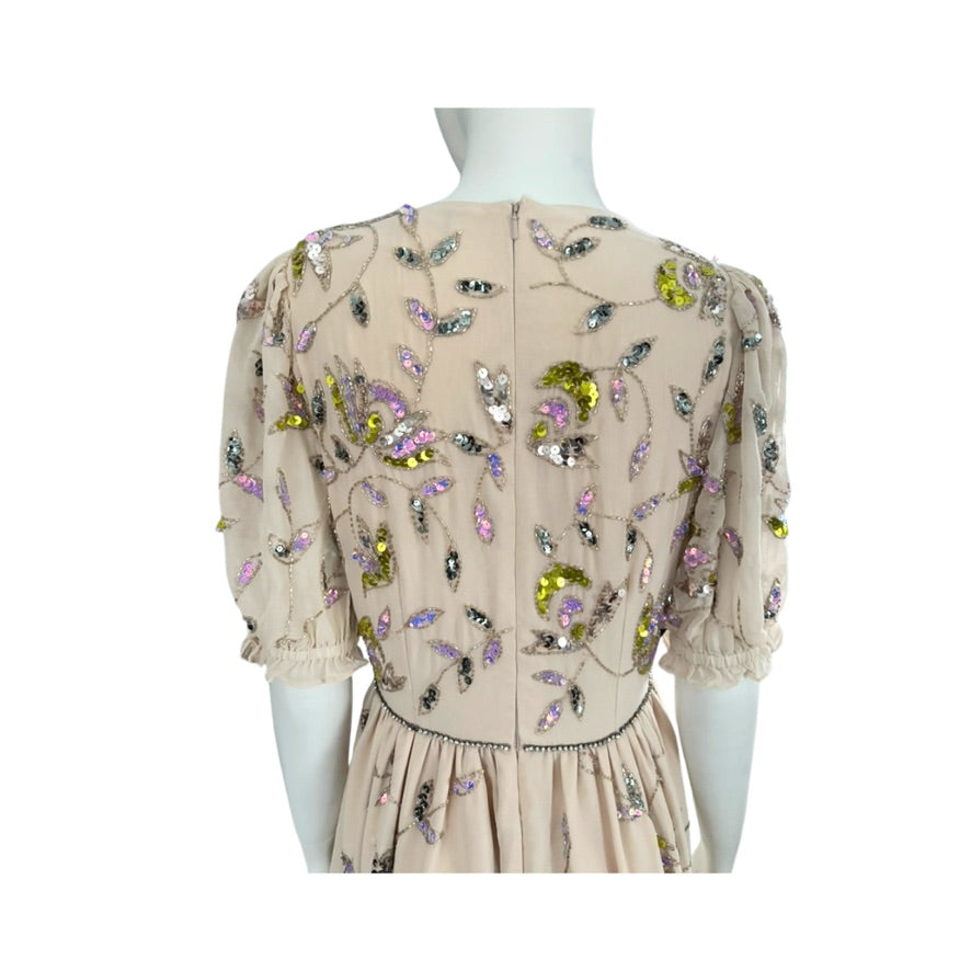 Beige dress with floral embroidery on a mannequin against a white background