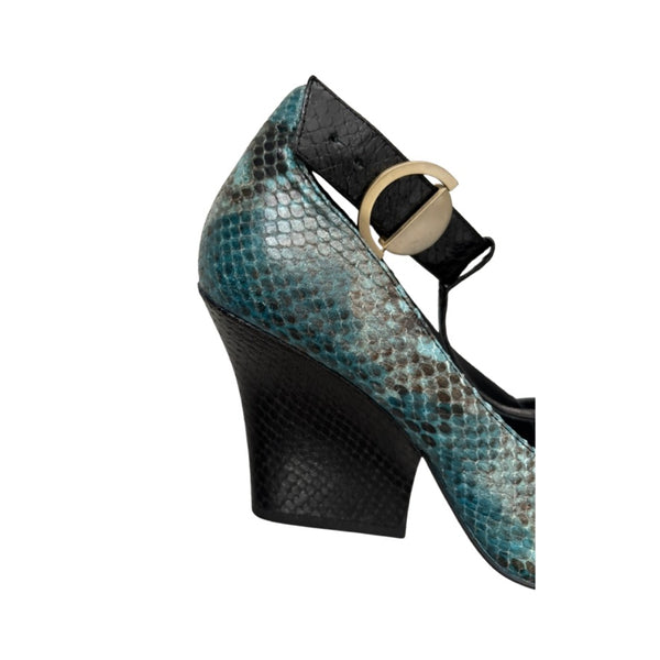 High-heeled shoe with snake print and black wedge sole on a white background