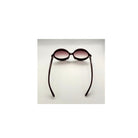 Sunglasses with black frame and pink-tinted lenses on a light gray background