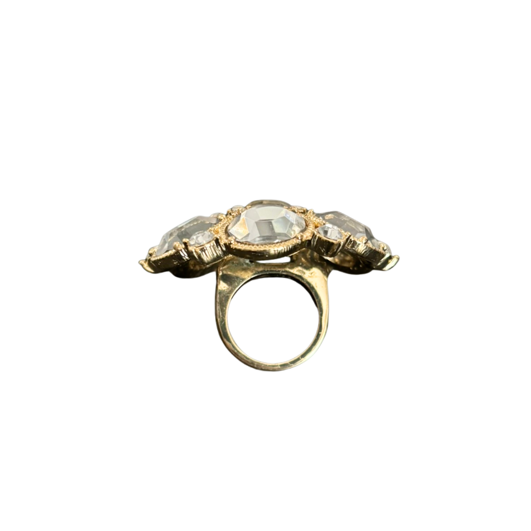 Gold ring with a central gemstone on a white background
