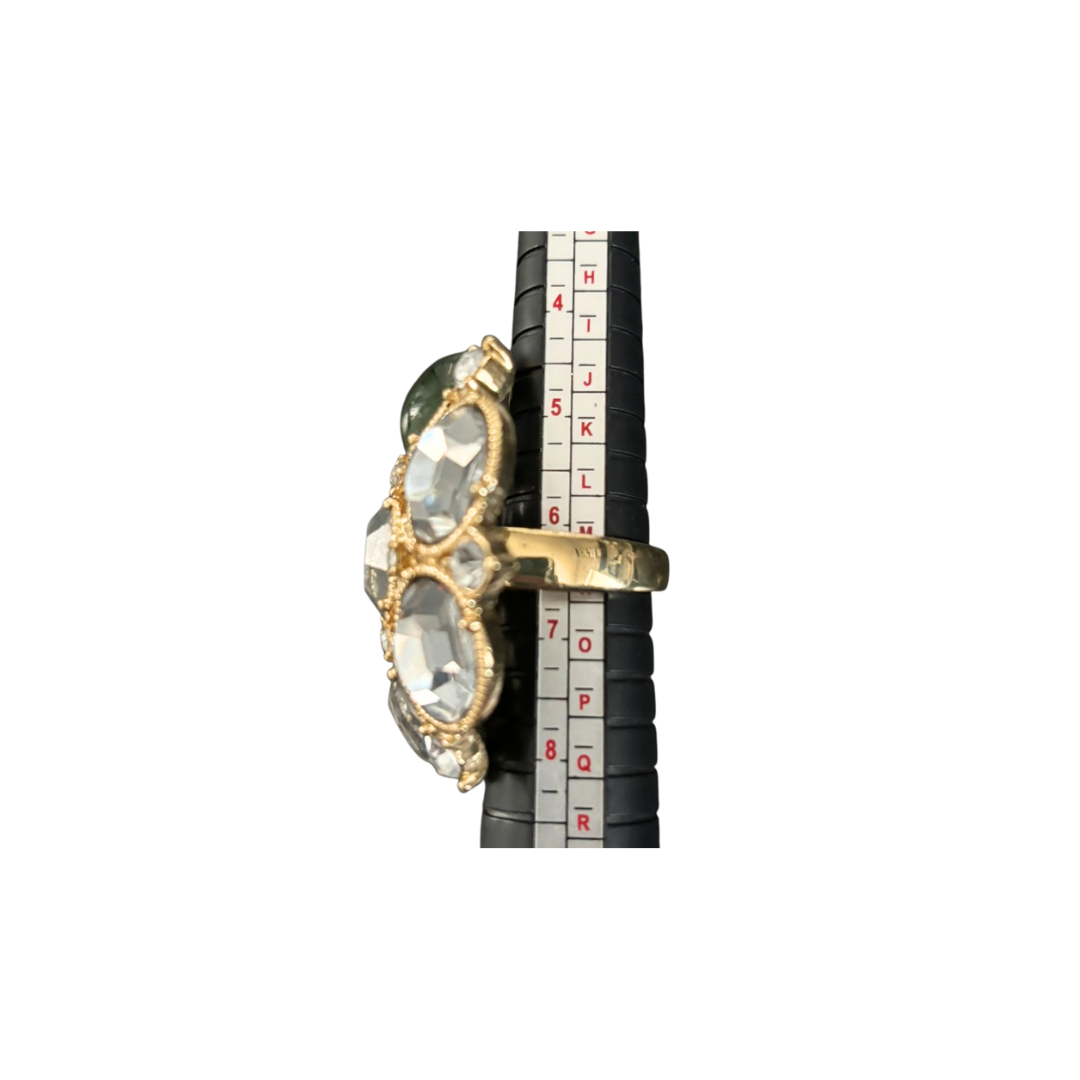 Gold ring with a large gemstone on a measuring tape background