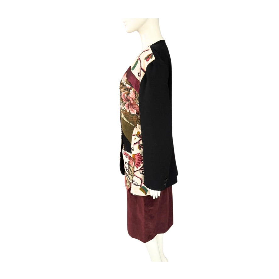 Mannequin wearing a black jacket with floral patterns and burgundy skirt on a white background