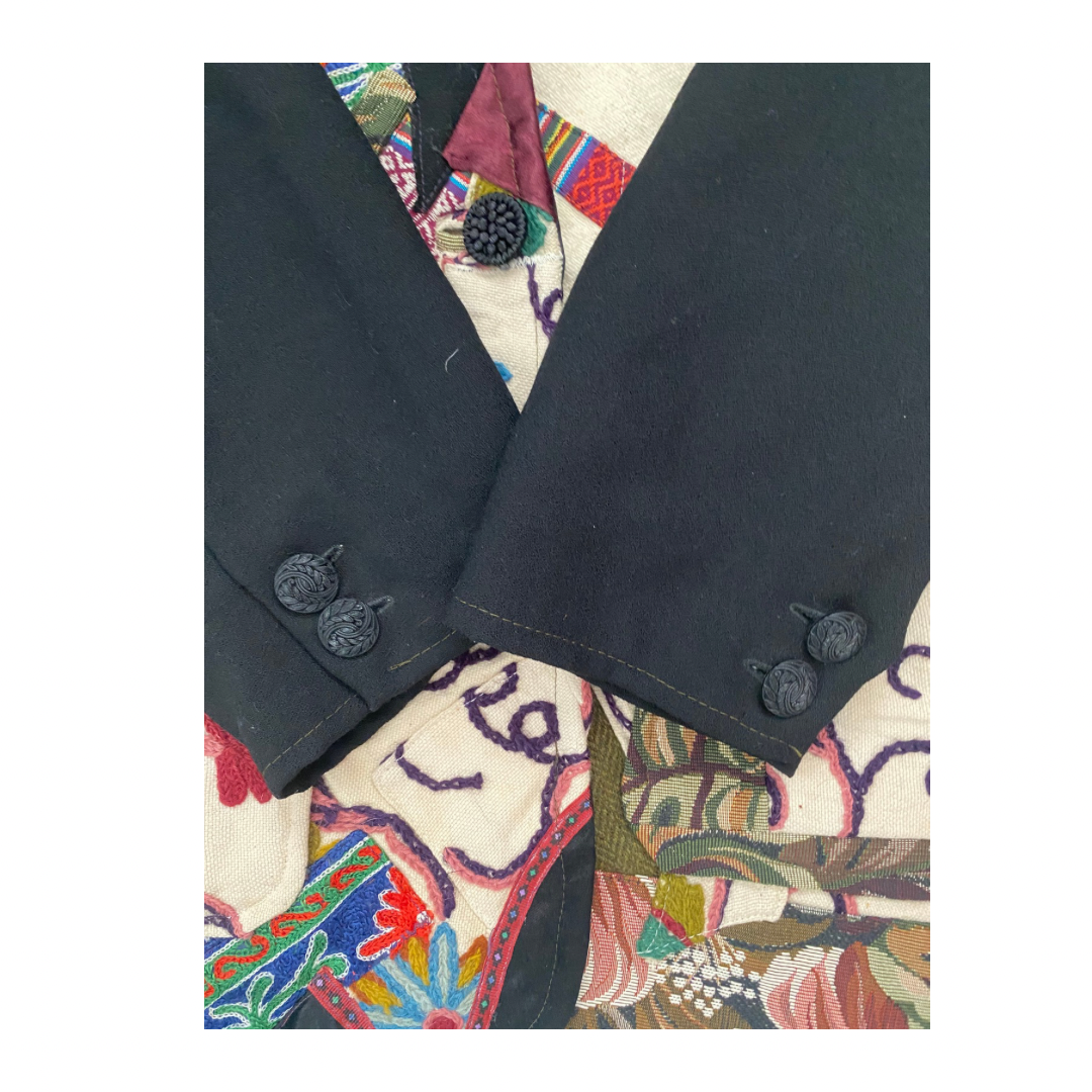 Close-up of a dark fabric with buttons on a colorful, patterned background