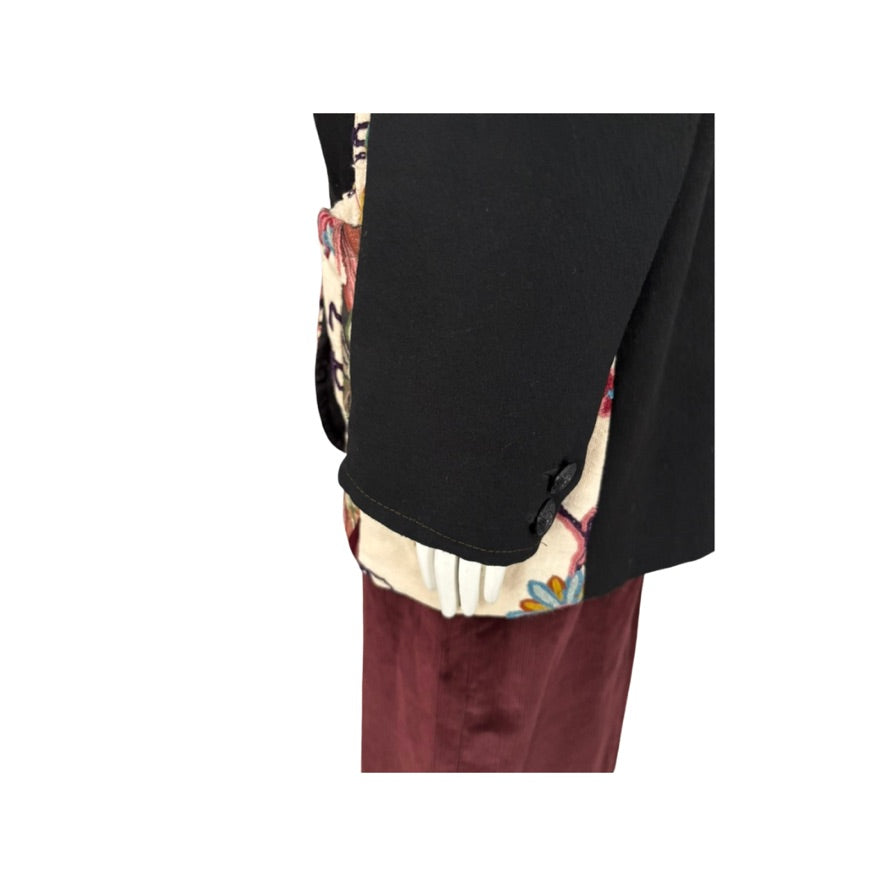 Close-up of a black  floral jacket cuff on a white background