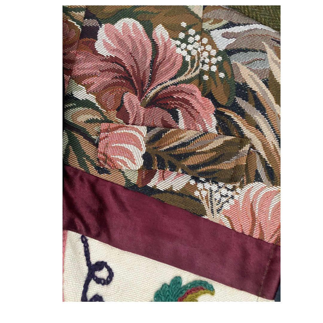 Close-up of a fabric with floral and leaf patterns in various colors.