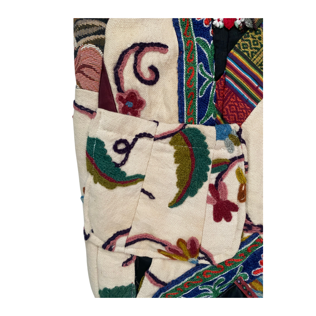 Colorful embroidered patchwork textile with intricate patterns on a white background