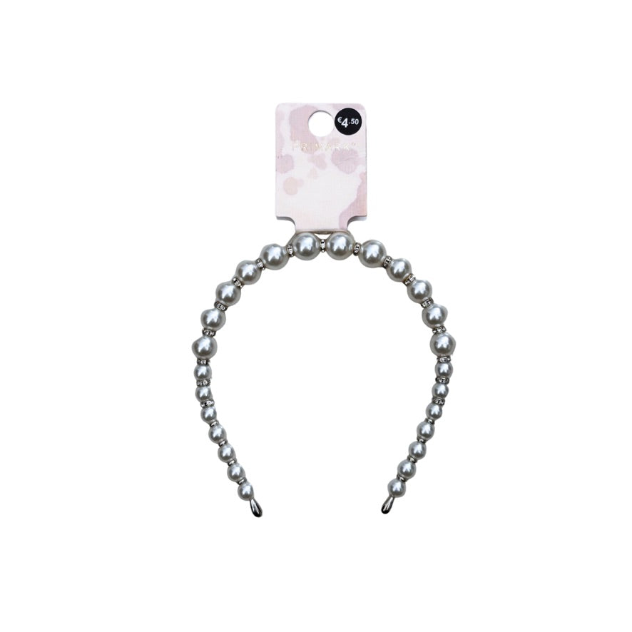 Silver beaded hairband with a pink and white patterned card on a white background