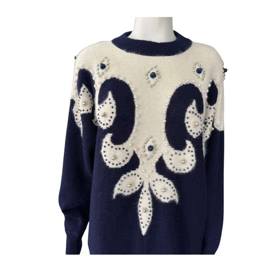Navy blue and white sweater with decorative patterns on a mannequin against a white background