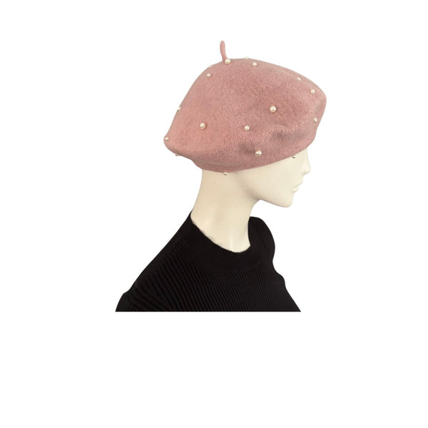 Pink beret with pearl embellishments on a mannequin head against a white background