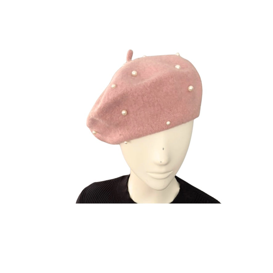 Pink beret with pearl embellishments on a mannequin head against a white background