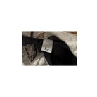 Size label 'L' on a piece of clothing with a camouflage pattern