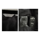Clothing labels with 'per una' and 'Marks & Spencer' branding on a black background.