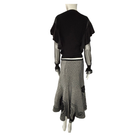 Mannequin wearing a black top and grey skirt on a white background