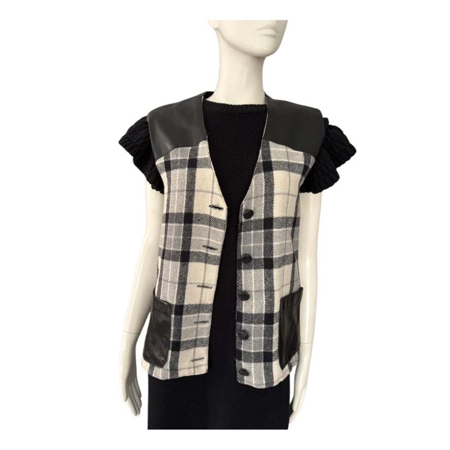 Plaid vest with black leather sleeves on a mannequin against a white background