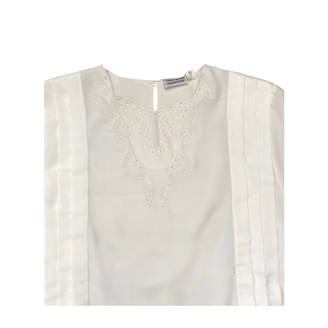White blouse with intricate embroidery on a white background