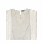 White blouse with intricate embroidery on a white background