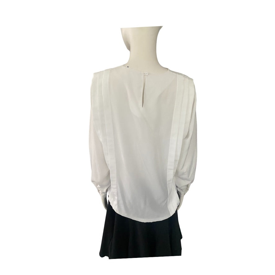 White blouse on a mannequin with a black skirt against a white background