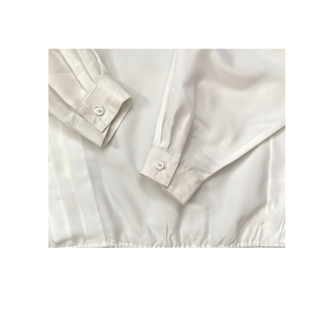 Close-up of a beige shirt with rolled-up sleeves on a white background