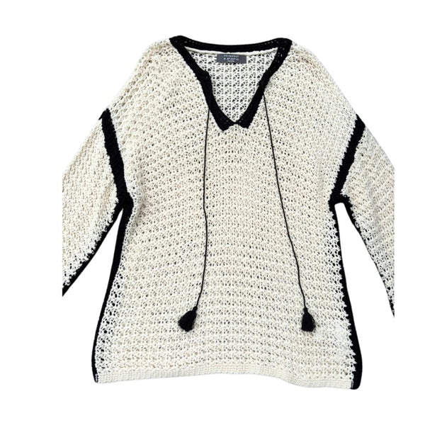 Cream sweater with black trim on a white background