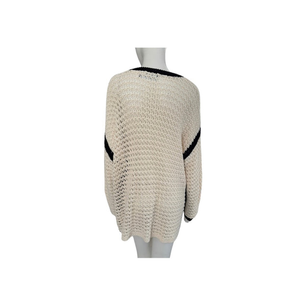 Beige knitted sweater with black accents on a mannequin against a white background