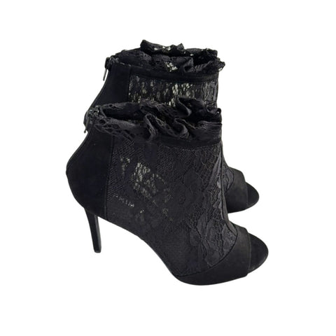 Black lace high-heeled shoes on a white background