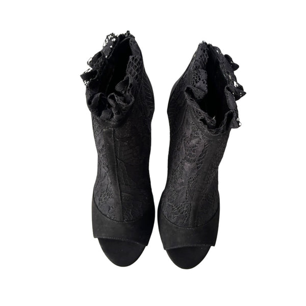 Pair of black lace socks with ruffled top on a white background