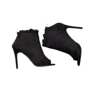 Black high-heeled ankle boots on a white background