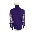 Purple turtleneck sweater with sheer sleeves on a mannequin against a white background