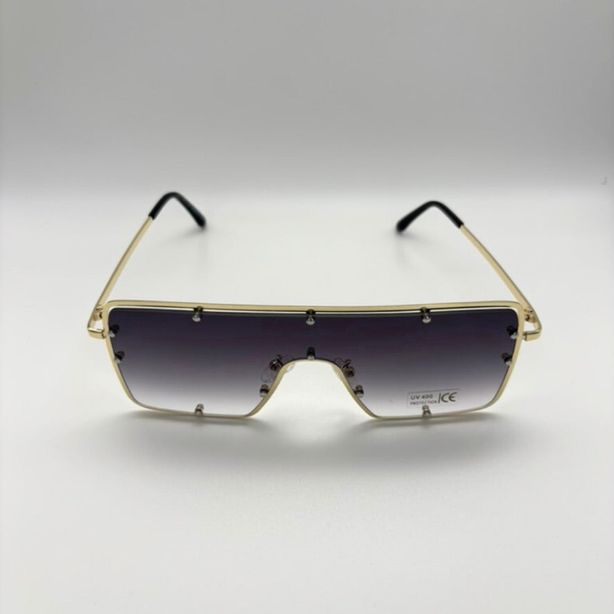Sunglasses with gold frame and black gradient lenses on a white background