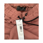 Pink garment with a brand tag on a white background