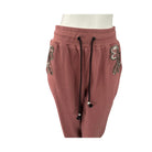 Pink sweatpants with sequin embellishments on a white background