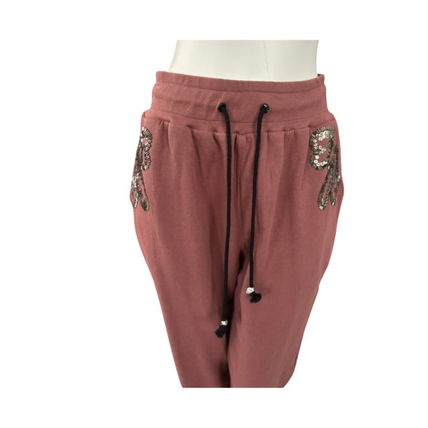 Pink sweatpants with sequin embellishments on a white background