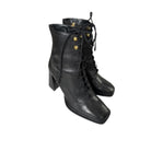 Pair of black leather lace-up boots on a white background