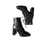 Black leather boots with block heels on a white background
