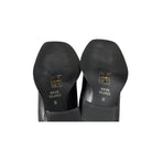 Black shoes with 'River Island' branding on the soles against a white background