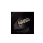 Close-up of a 'River Island Leather' label on a dark background