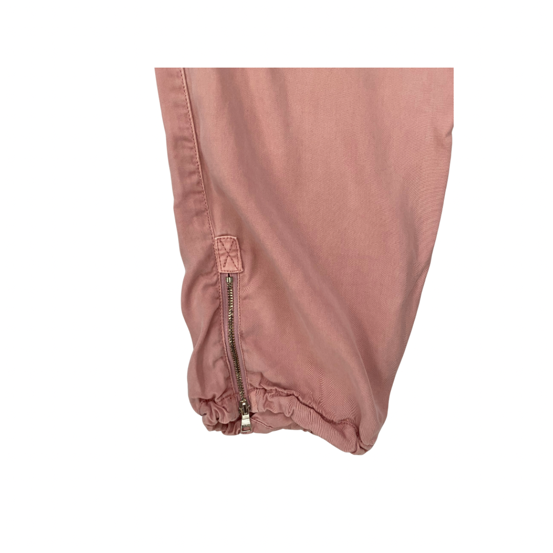 Close-up of a pink pants leg with a zipper on a white background