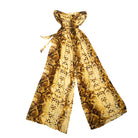 A strapless jumpsuit with a snakeskin print in yellow, brown, and gold, featuring a tie-back strap and wide leg design.