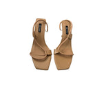 Pair of tan high-heeled sandals on a white background