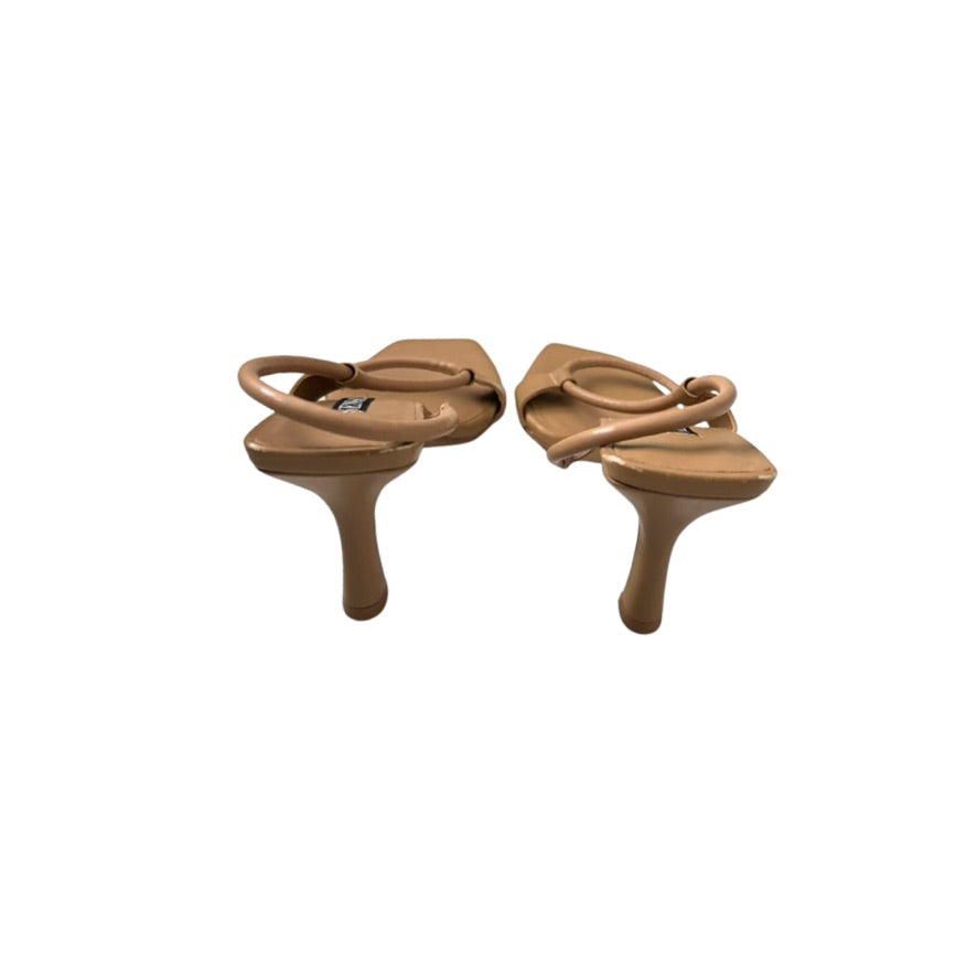 Pair of tan sandals on a white background