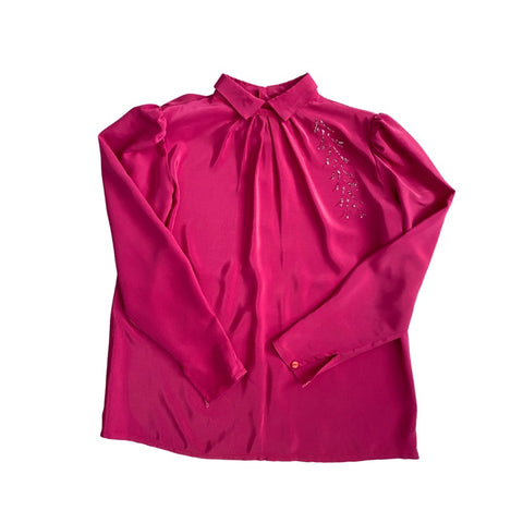 Pink blouse with long sleeves and decorative elements on a white background